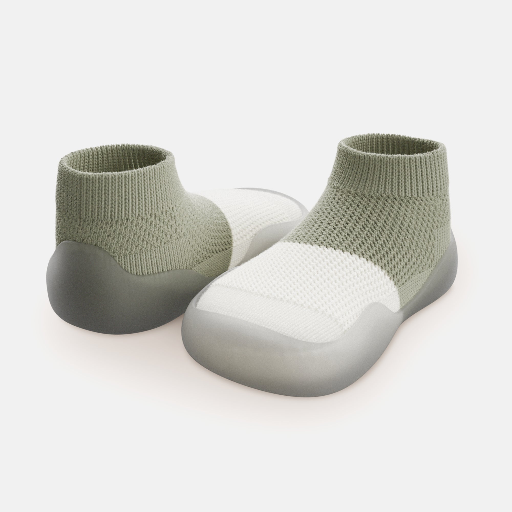 Two green and white knit slip-on shoes with gray soles.