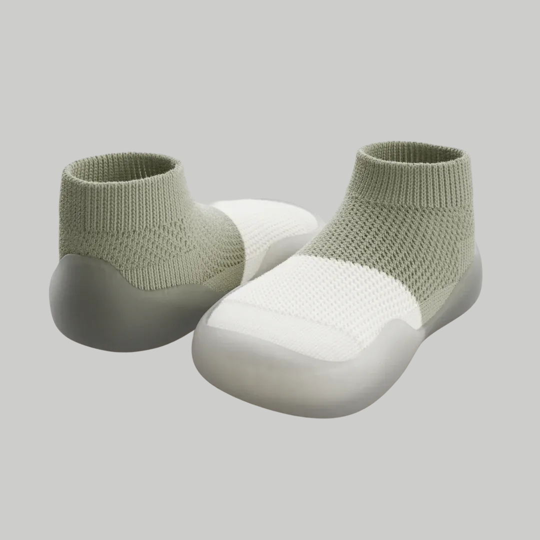 Two green and white knit slip-on shoes with gray soles.